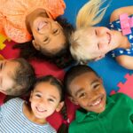 children laying in a circle, happy